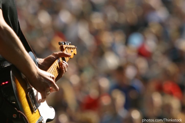 Guitarist strumming guitar at concert