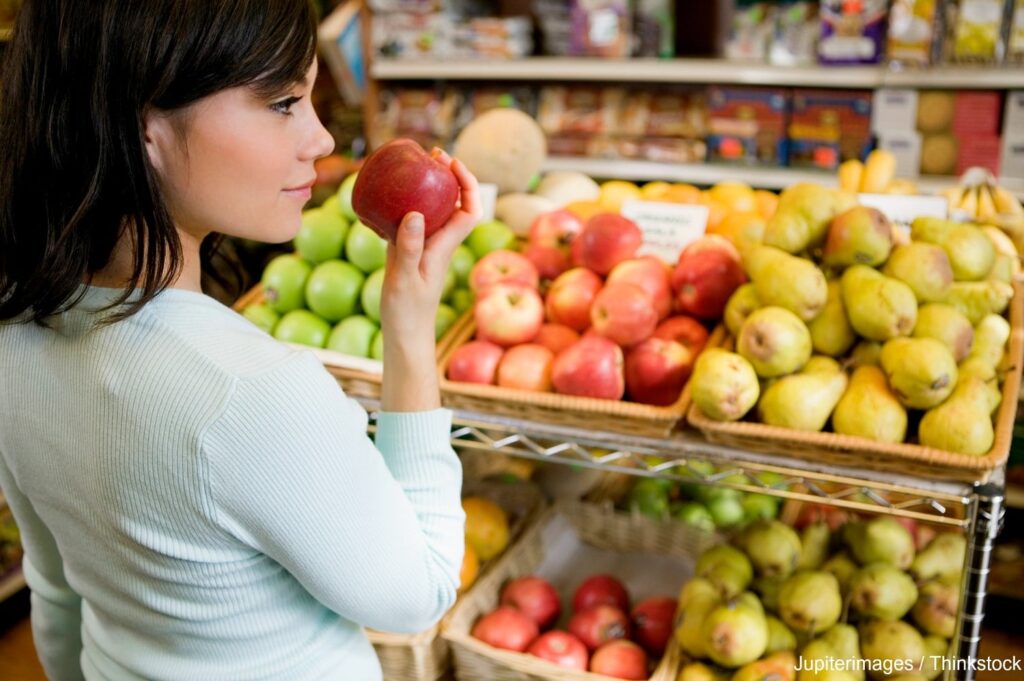 Woman smelling an apple at a farmers market in Bethlehem, PA