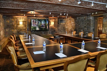 water bottles sit on a u-shaped brown meeting table at sayre mansion