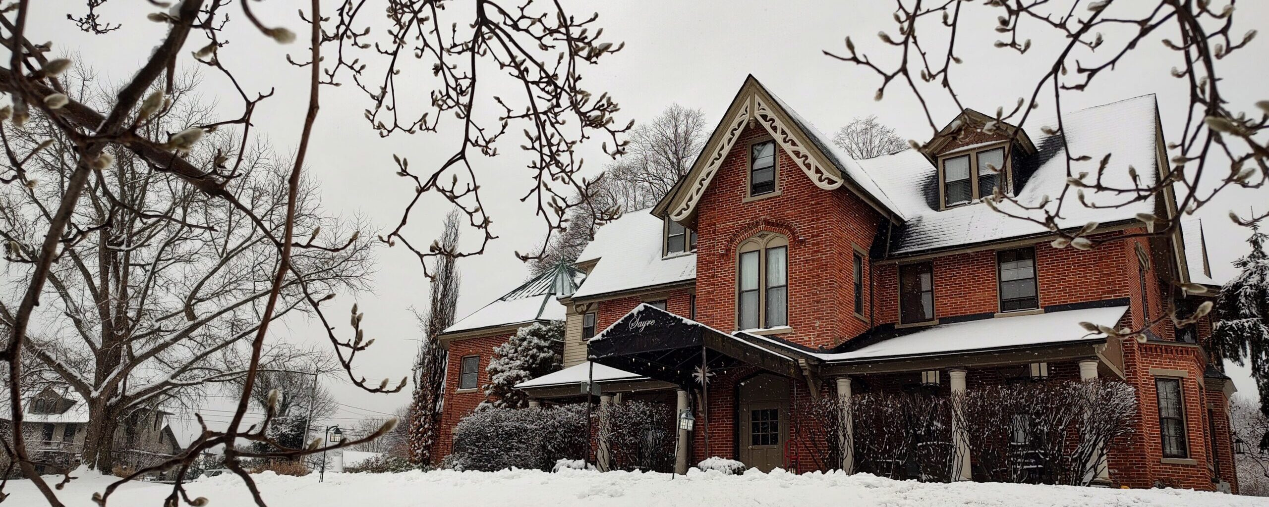 the red brick of the Sayre Mansion front exterior stands out against the winter snow in Bethlehem