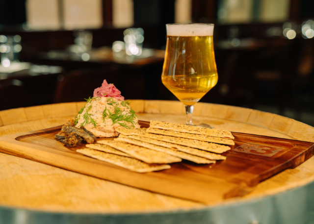 board with crackers and dip and a drink next to it