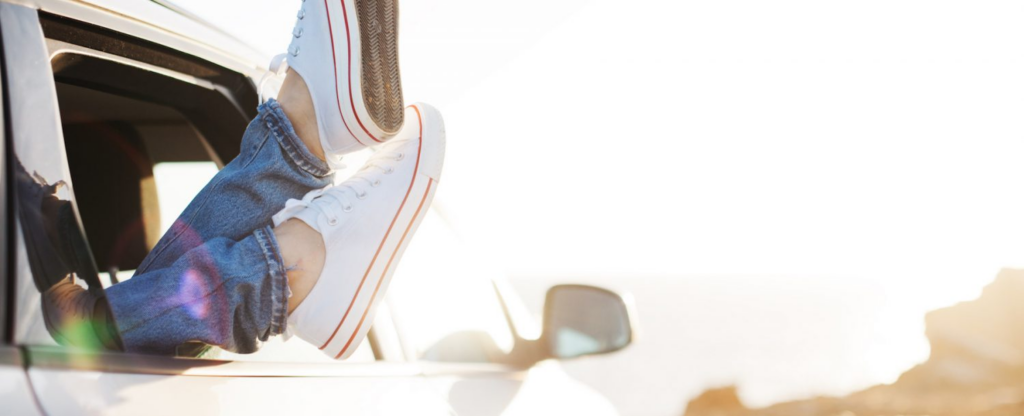 woman's feet hanging out car window