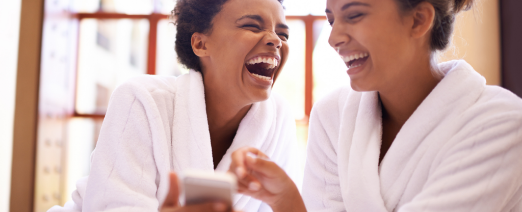 two women in robes laughing together