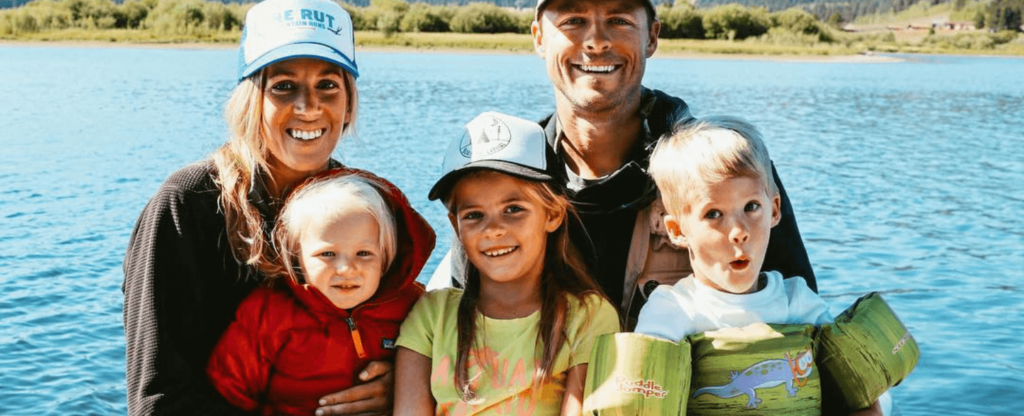 family posing for photo with lake in the background