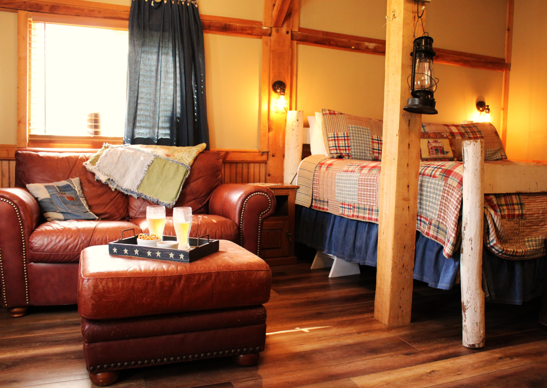 barn interior view of king bed and leather loveseat