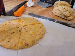 Sweet potato scone dough in a round cut into 10 triangles.