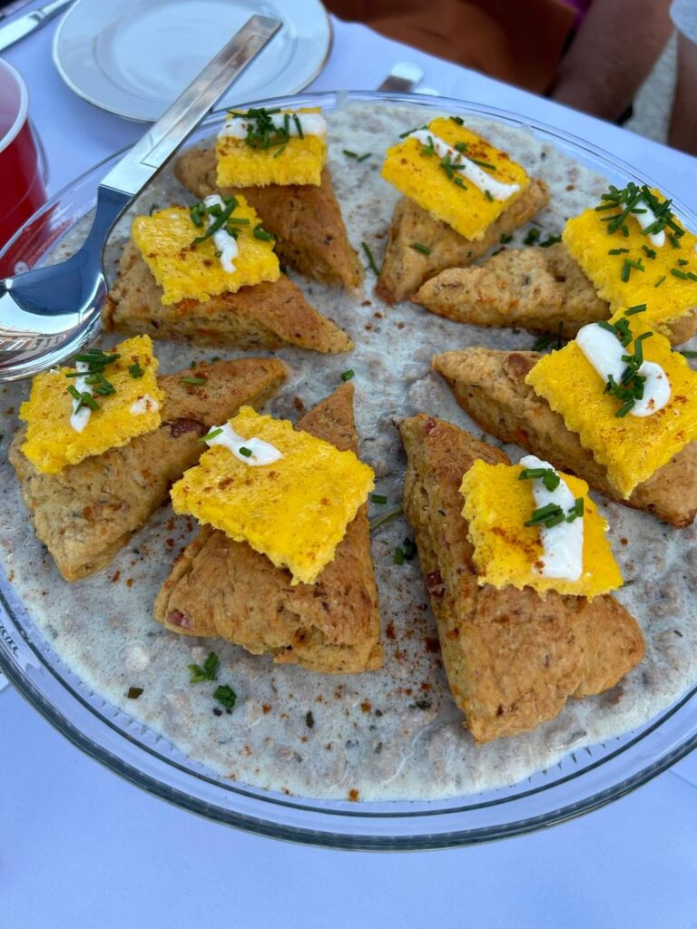 Farm to Fork 2023 Platter of Sweet Potato Scones over Pork Sausage Gravy topped with egg and goat cheese.