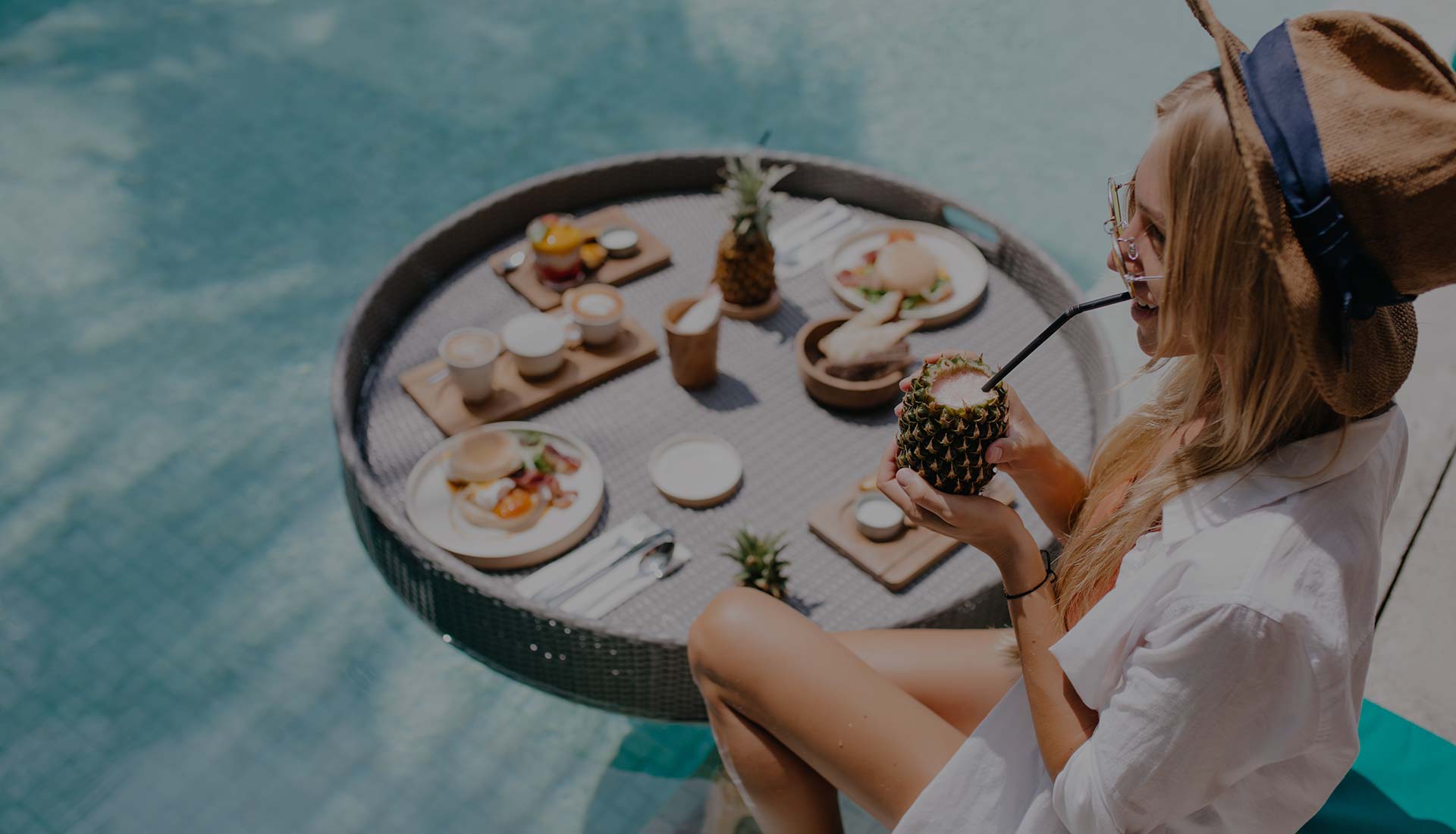 woman sips a drink by the pool