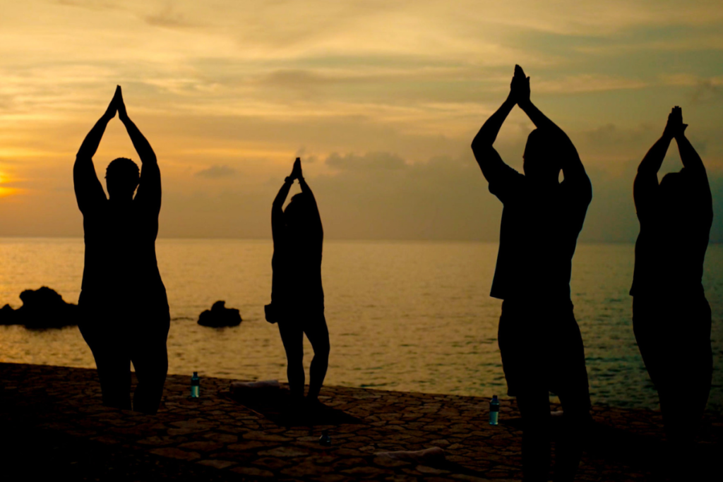 cliffside yoga group at sunset