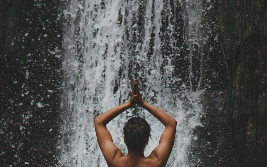 woman poses in front of waterfall