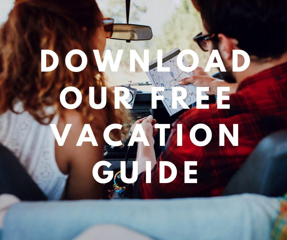 Couple on a road trip with overlaying text "download free Vacation Guide"
