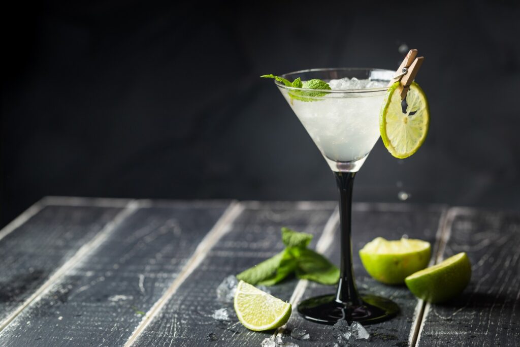 Fresh classic lime margarita cocktail over black background