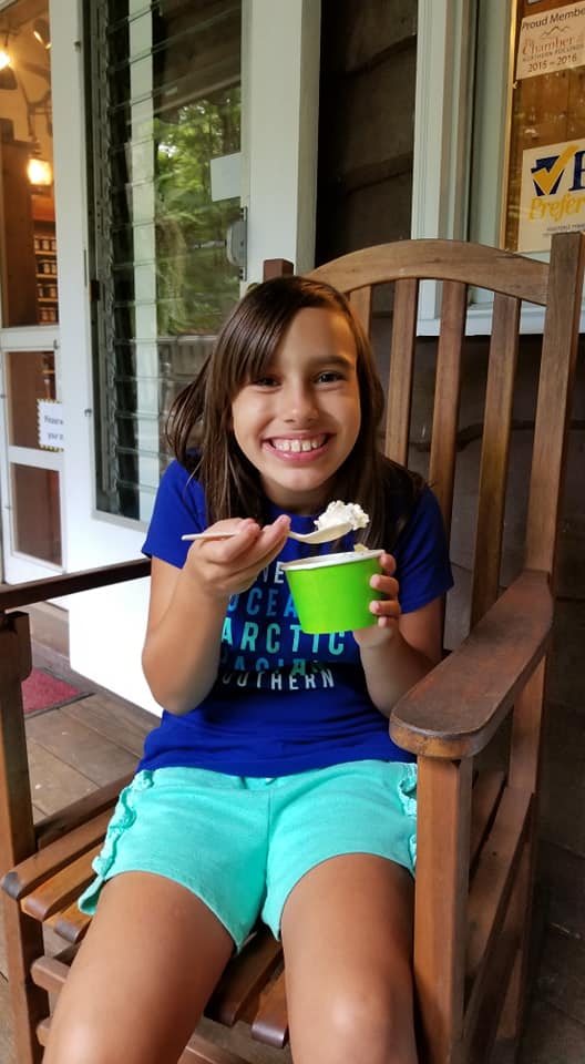 girl smiles and eats ice cream