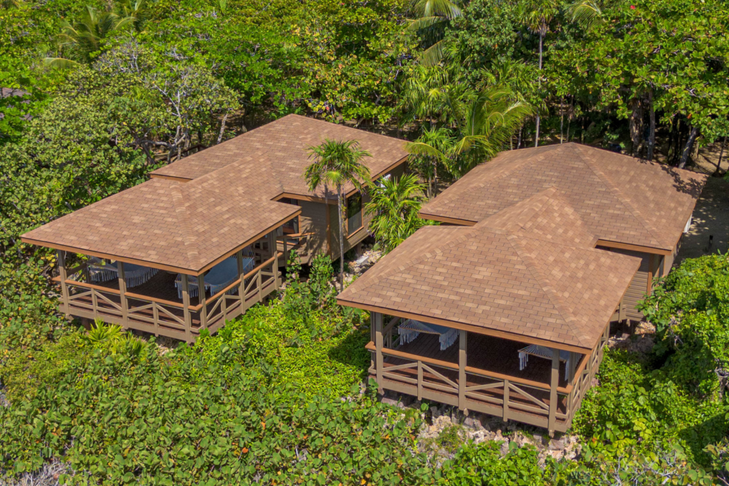  Key Deluxe Bungalow in Roatan with ocean views, wicker seating, and a handwoven hammock overlooking the Caribbean Sea.