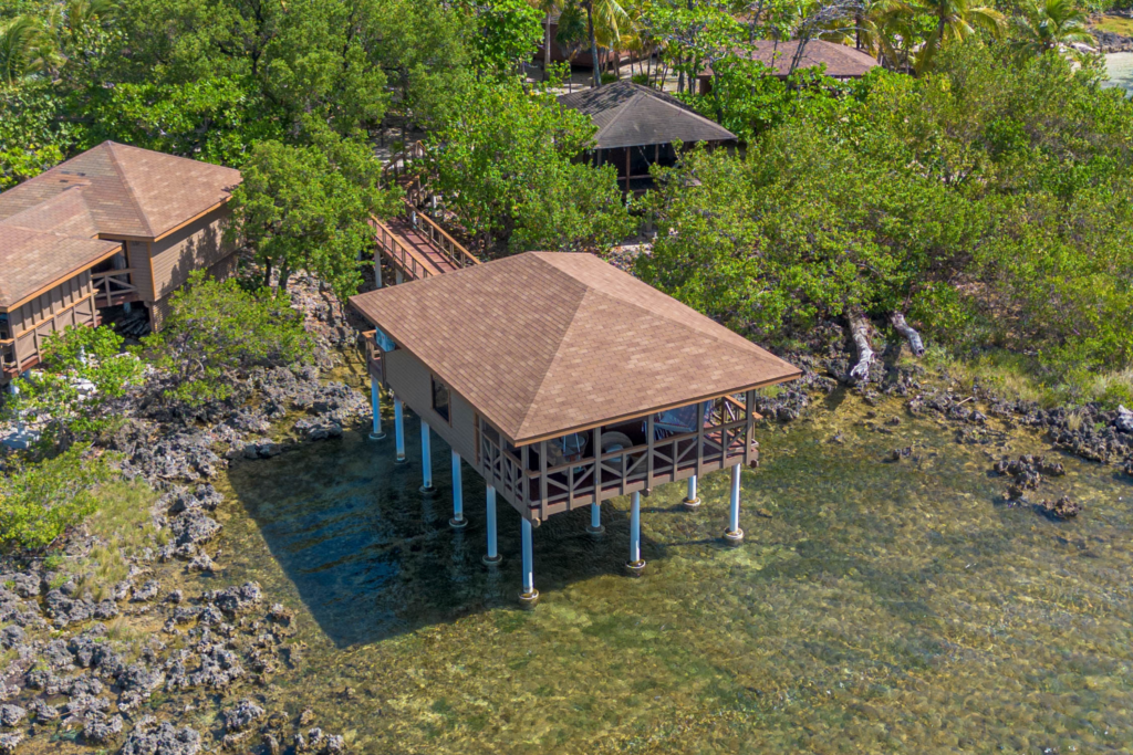  Key Deluxe Bungalow in Roatan with ocean views, wicker seating, and a handwoven hammock overlooking the Caribbean Sea.