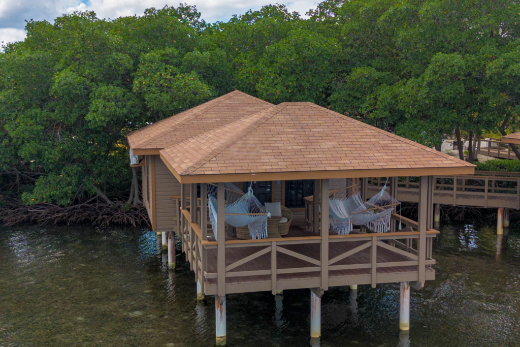 Key Deluxe Bungalow in Roatan with ocean views, wicker seating, and a handwoven hammock overlooking the Caribbean Sea.