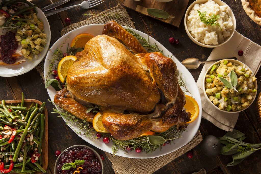 a baked turkey at the center of a thanksgiving spread