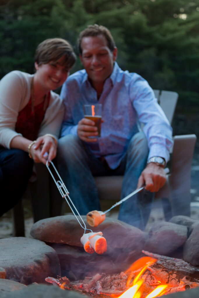 couple roast marshmallows over a firepit