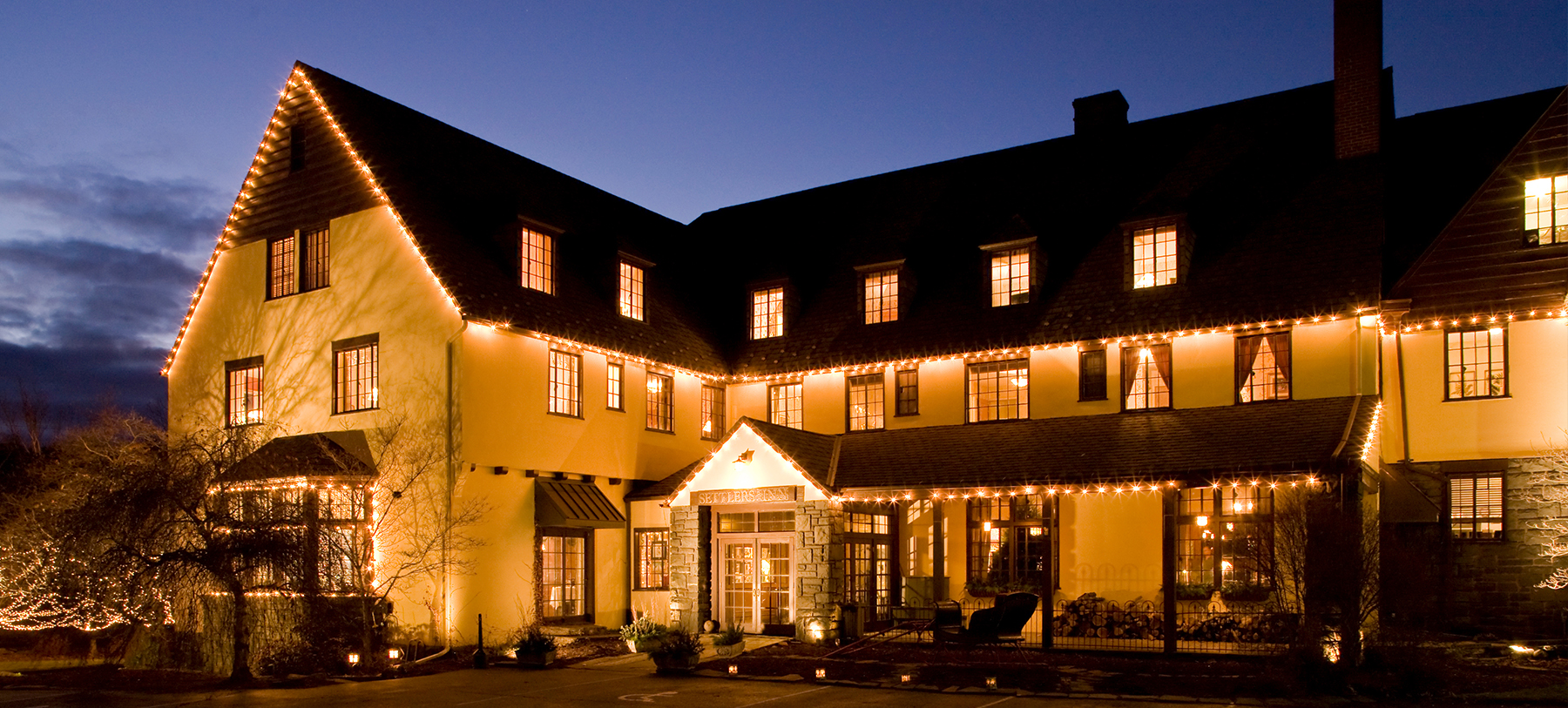 a historic poconos hotel at nighttime, lit with yellow lights