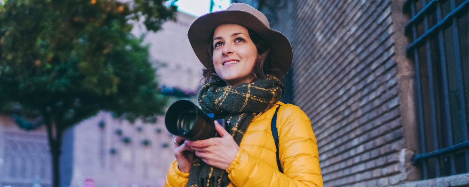 woman in winter coat with camera, solo travel