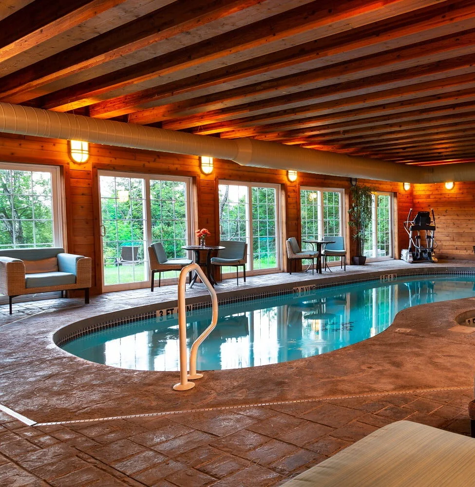 The French Manor indoor pool with lights softly accenting the pool; one of several amenities we offer
