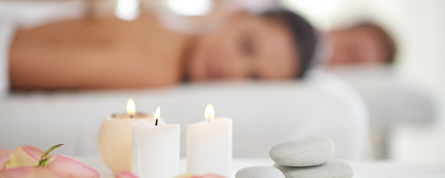Couple getting massage with candles in the foreground