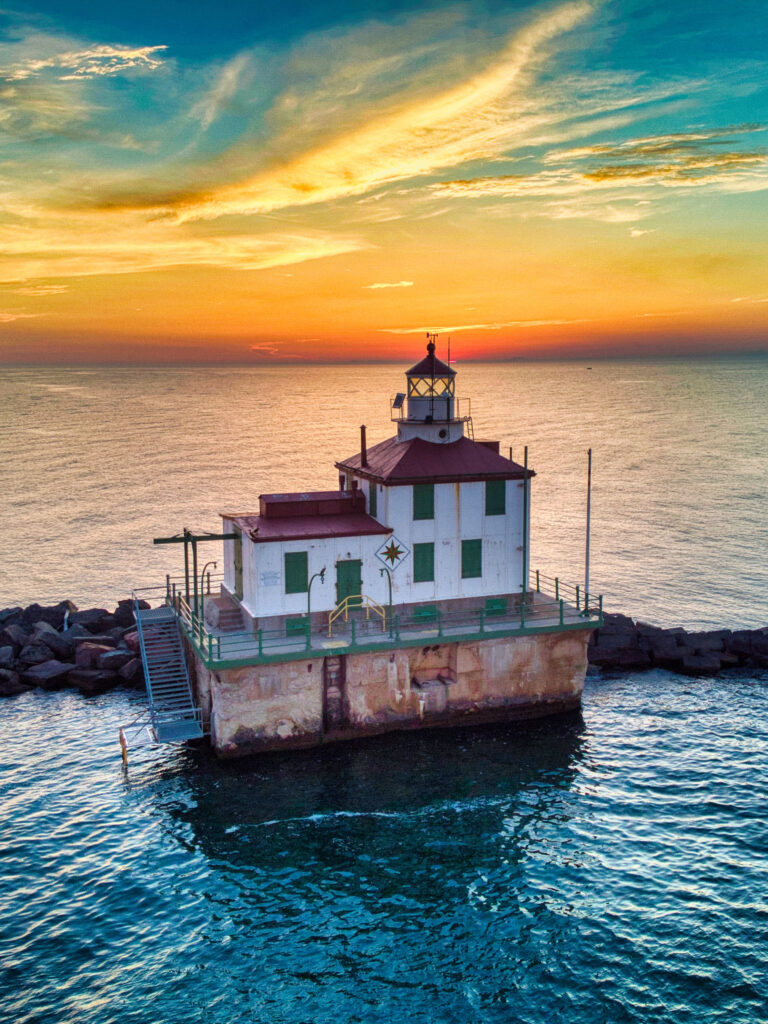 A drone shot of the Ashtabula Harbor Light building during a breathtaking sunset
