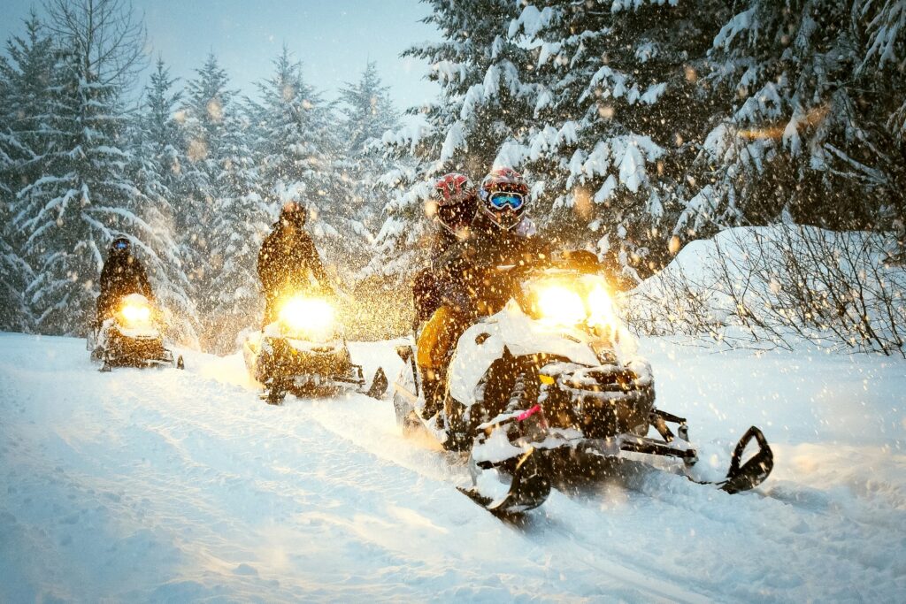 Visitors Enjoying a Snowmobile in Leavenworth During a Gentle Snowfall