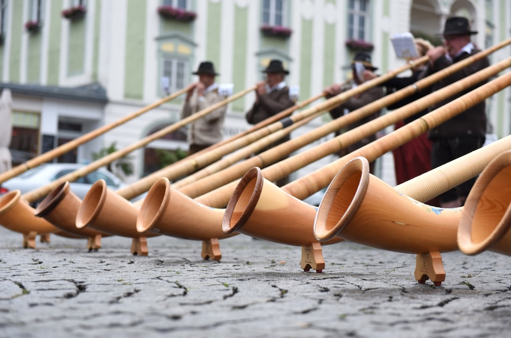 Alphorn players in a city square playing music