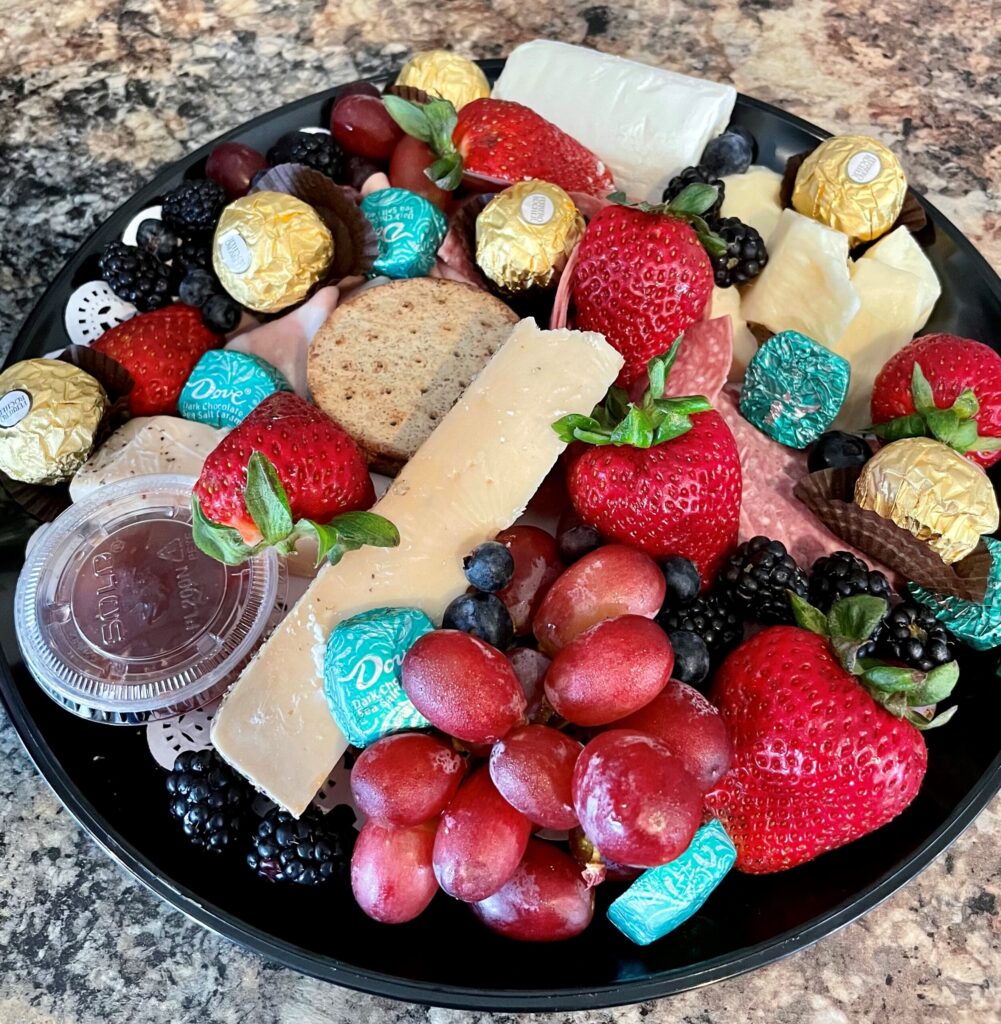Cheese Tray with a variety of cheese, meats, fruit and chocolate
