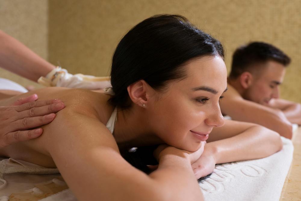 A woman and man receiving a couple's massage at a spa